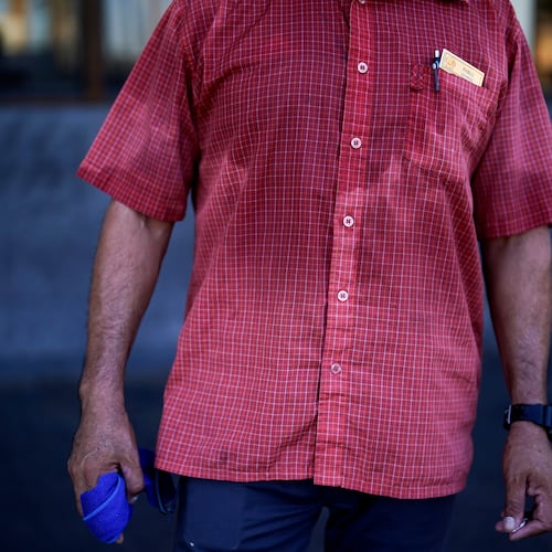 FILE - A man's shirt is bathed in sweat before seven in the morning as he parks cars and provides security for a downtown cafe July 20, 2023, in Mexicali, Mexico. (AP Photo/Gregory Bull, File)