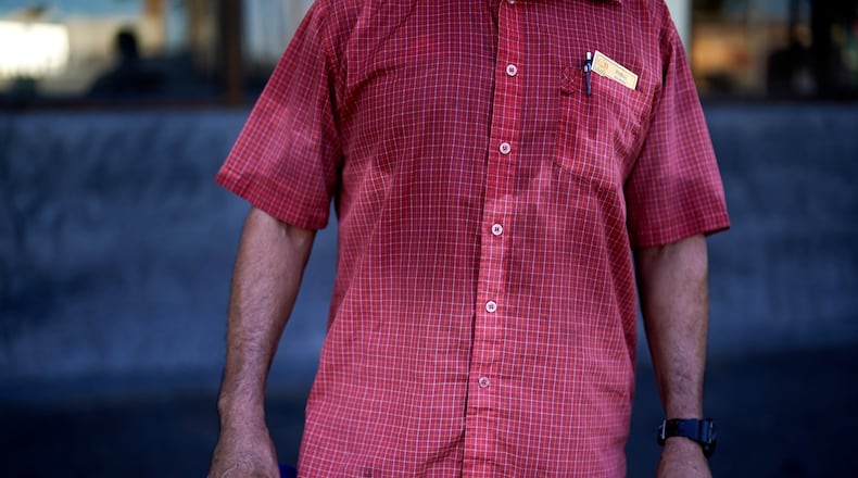 FILE - A man's shirt is bathed in sweat before seven in the morning as he parks cars and provides security for a downtown cafe July 20, 2023, in Mexicali, Mexico. (AP Photo/Gregory Bull, File)