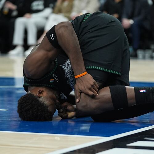 Minnesota Timberwolves guard Anthony Edwards kneels on the court after sustaining an injury during the first half of Game 4 of a first-round NBA basketball playoff series against the Denver Nuggets, Saturday, April 25, 2026, in Minneapolis. (AP Photo/Abbie Parr)