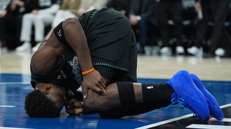 Minnesota Timberwolves guard Anthony Edwards kneels on the court after sustaining an injury during the first half of Game 4 of a first-round NBA basketball playoff series against the Denver Nuggets, Saturday, April 25, 2026, in Minneapolis. (AP Photo/Abbie Parr)