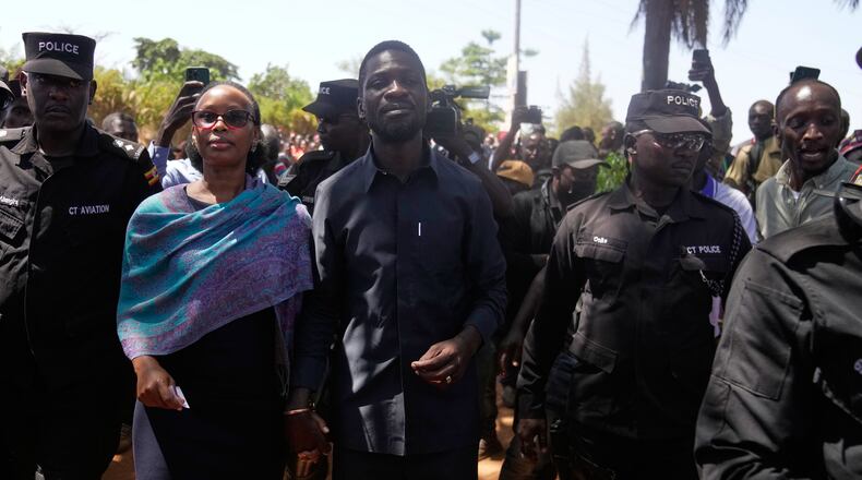 Uganda opposition presidential candidate Robert Kyagulanyi Ssentamu, famously known as Bobi Wine of the National Unity Platform (NUP), arrives with his wife to cast their votes, during the presidential election at a polling station, in Kampala, Uganda, Thursday, Jan. 15, 2026. (AP Photo/Brian Inganga)