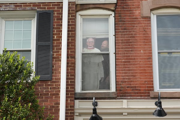 The Rev. Zachary Swantek, Princeton’s Catholic chaplain, stands for a portrait next to a cardboard image of Pope Leo XIV on display on a window at the Aquinas Institute, the university’s Catholic campus ministry, in Princeton, N.J., on Thursday, May 15, 2025. (AP Photo/Luis Andres Henao)