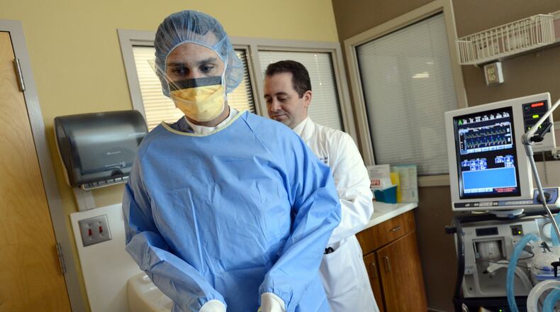 Dr. David Murphy (right) helps Dr. Justin Schrager as they prepare placing central line in a patient’s room at Medical ICU of Grady Memorial Hospital on Friday, April 5, 2013. Dr. David Murphy, leader of a successful effort at Grady to reduce hospital infections.