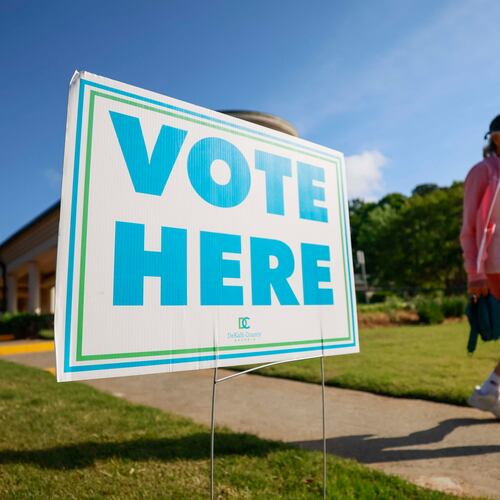 A person walks past a voting sign during the first day of early voting for the primary elections at the Dunwoody Library on Monday. (Miguel Martinez/AJC)