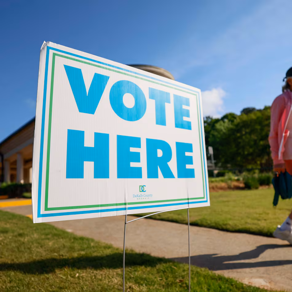 A person walks past a voting sign during the first day of early voting for the primary elections at the Dunwoody Library on Monday, April 27, 2026. (Miguel Martinez/AJC)