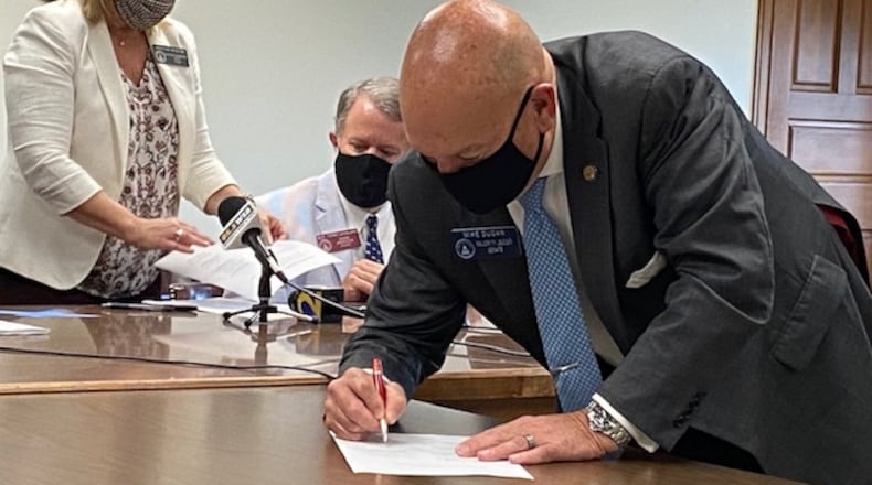 Senate Majority Leader Mike Dugan, R-Carrollton, signs the fiscal 2021 budget deal that cuts state spending by $2.2 billion. James Salzer/james.salzer@ajc.com