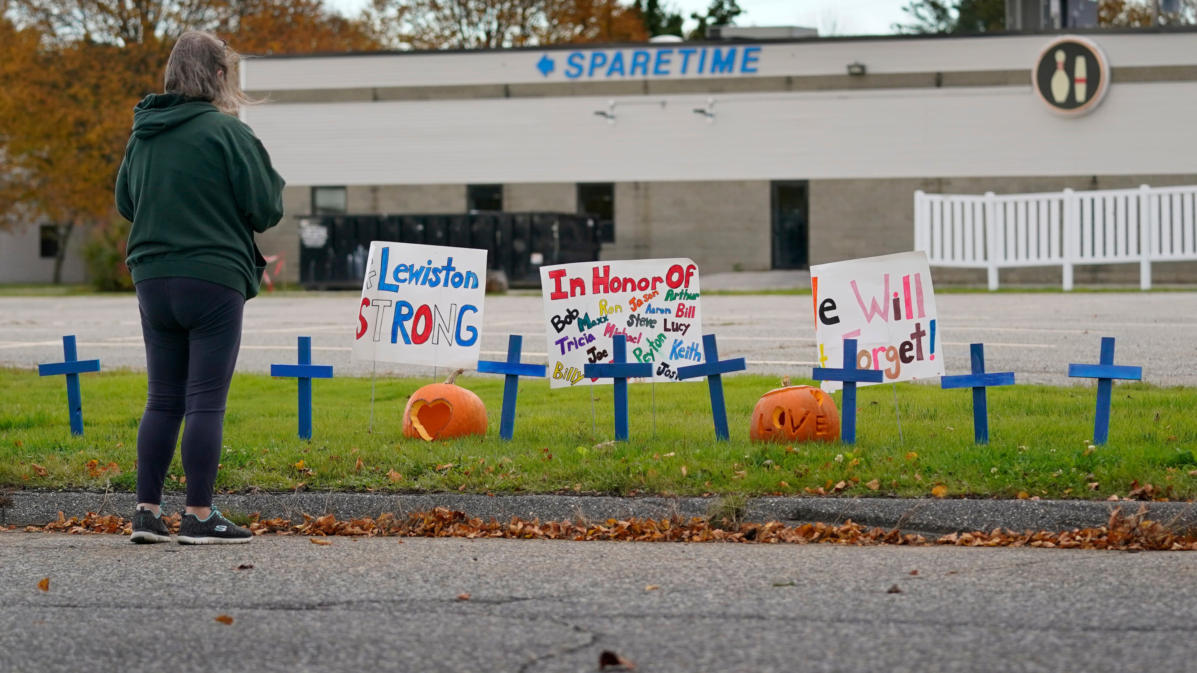 FILE - A woman visits a makeshift memorial outside Sparetime Bowling Alley, the site of a mass shooting, Oct. 28, 2023, in Lewiston, Maine. (AP Photo/Robert F. Bukaty, File)