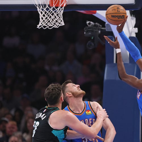 Oklahoma City Thunder guard Shai Gilgeous-Alexander, right, shoots next to Portland Trail Blazers center Donovan Clingan, left, and Thunder center Isaiah Hartenstein during the first half of an NBA basketball game, Sunday, Nov. 23, 2025, in Oklahoma City. (AP Photo/Nate Billings)