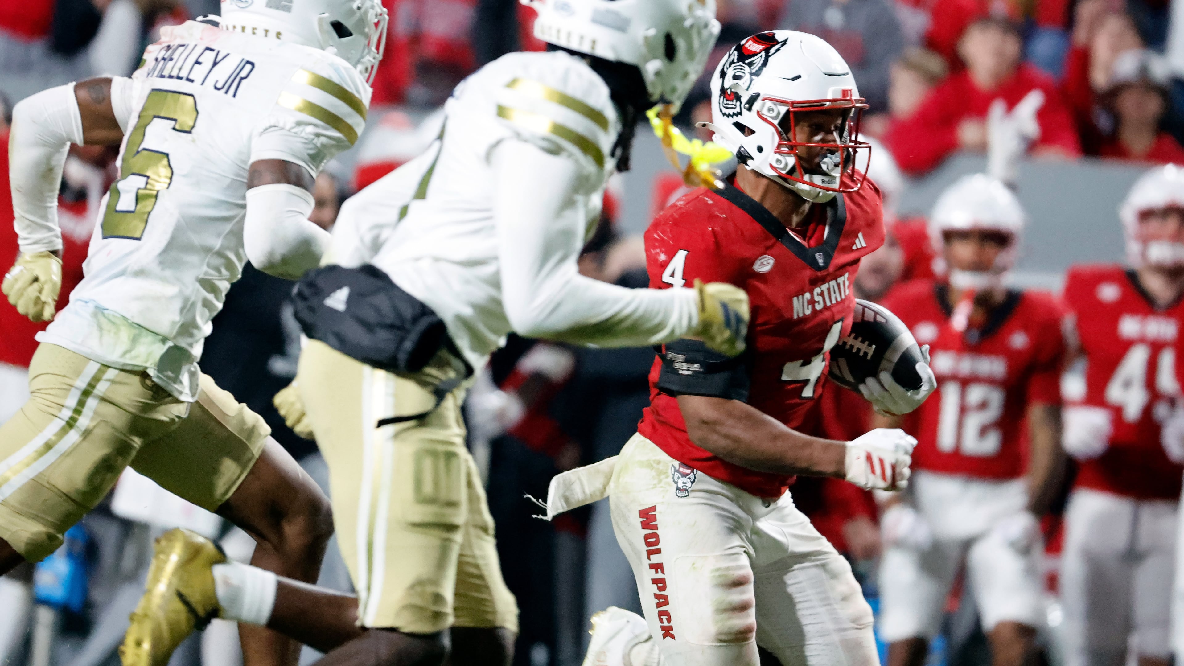 North Carolina State running back Jayden Scott (4) runs the ball away from Georgia Tech defenders during the second half of an NCAA college football game in Raleigh, N.C., Saturday, Nov. 1, 2025. (AP Photo/Karl DeBlaker)