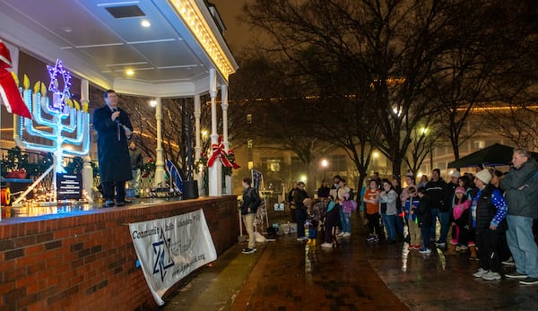 Congregation Ner Tamid’s Rabbi Joseph Prass leads a menorah lighting on the fifth night of Hanukkah on Saturday, Dec 28, 2024. The temple provided arts and crafts, food, music, dreidels, gifts and community at the Glover Park Stage in Marietta Square. This year's menorah lighting in Marietta Square will be Dec. 20, 2025. (Jenni Girtman for The Atlanta Journal-Constitution)