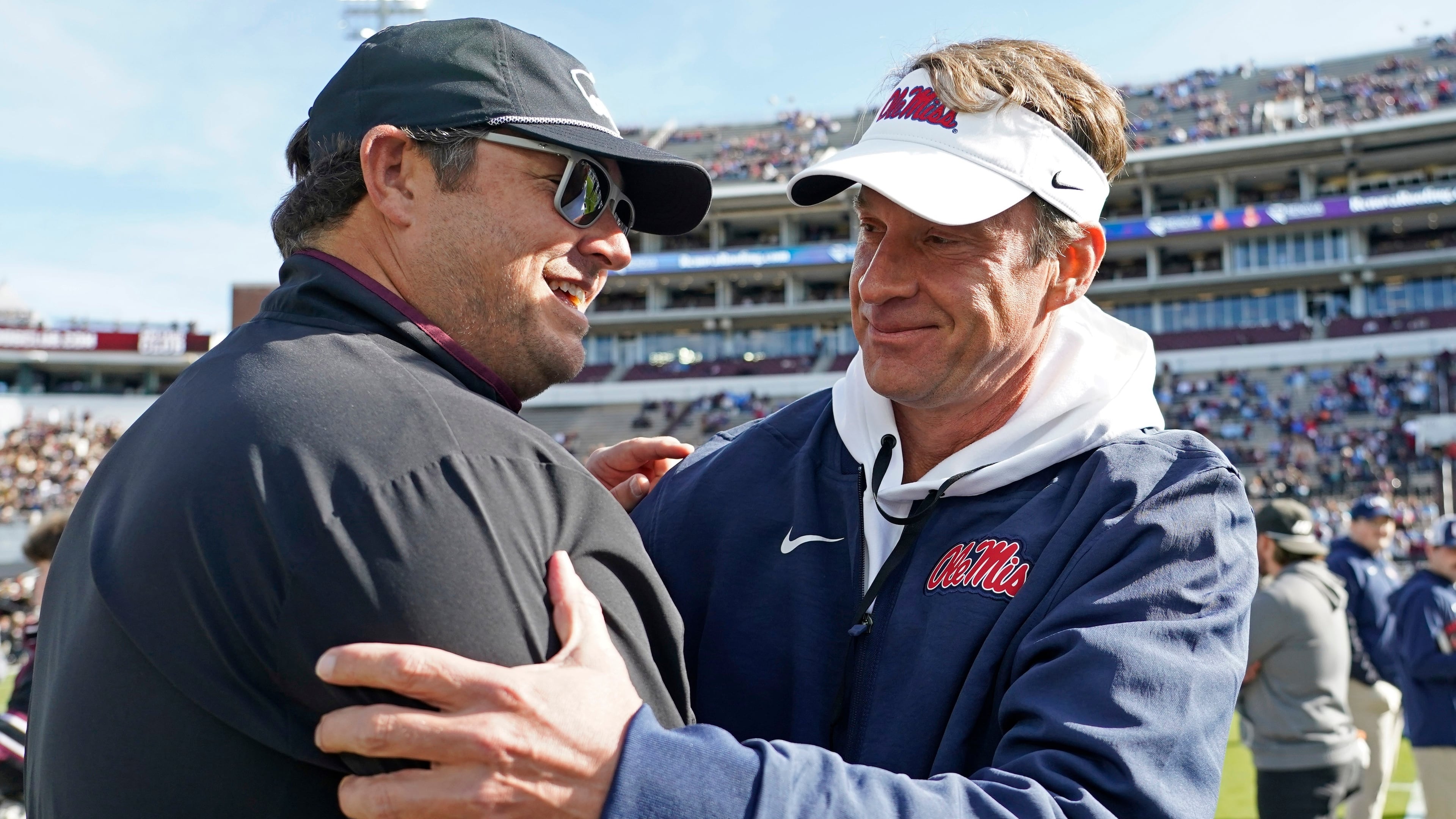 Mississippi head coach Lane Kiffin, right, greets Mississippi State head coach Jeff Lebby prior to their NCAA college football game Friday, Nov. 28, 2025, in Starkville, Miss. (AP Photo/Rogelio V. Solis)