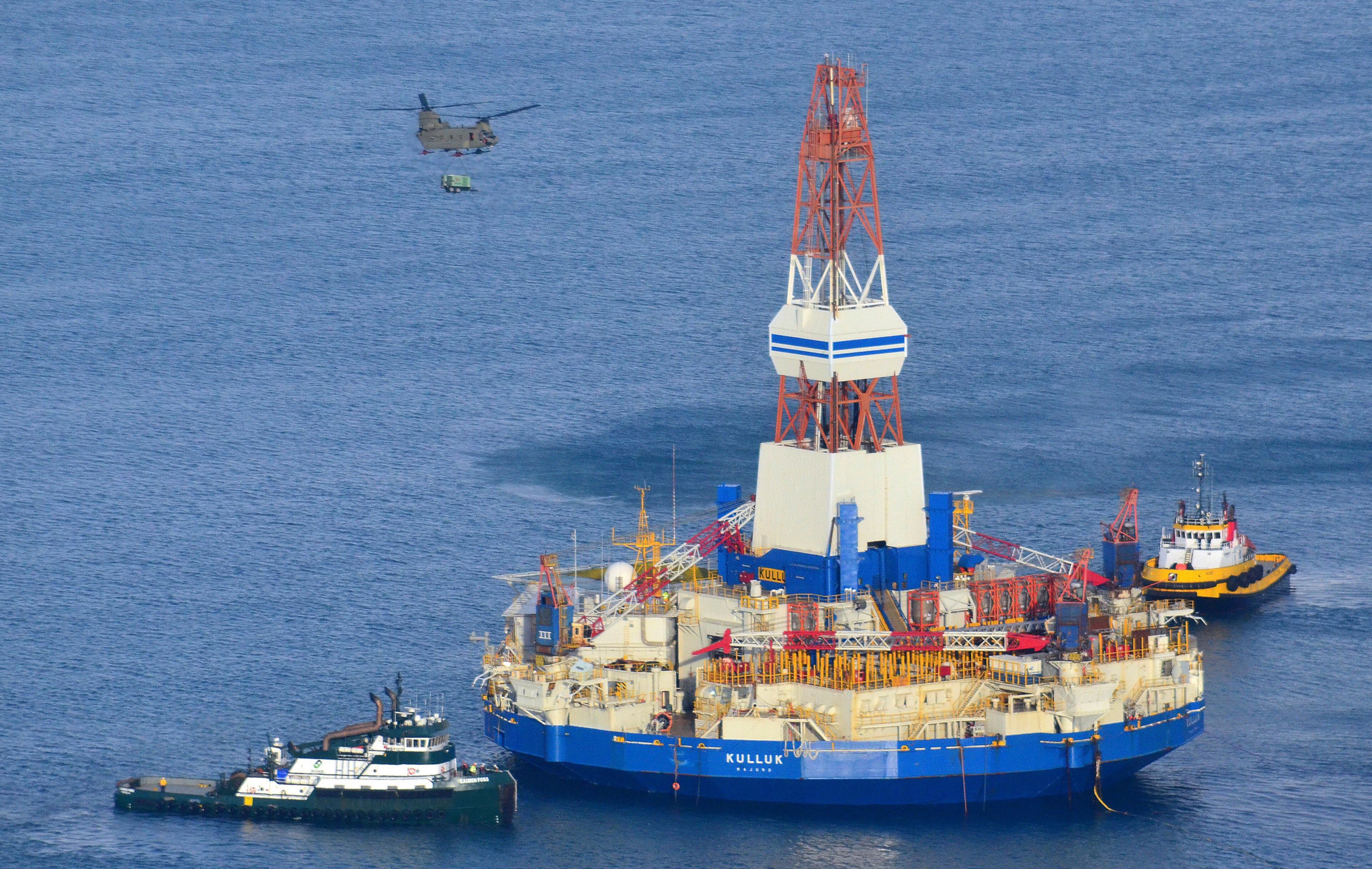 A U.S. Army CH-47 Chinook helicopter flies over the Kulluk, the Shell floating drilling barge off Kodiak Island in Alaska’s Kiliuda Bay as salvage teams conduct an in-depth assessment of its seaworthiness. (James Brooks/Kodiak Daily Mirror via AP)