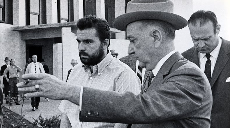 Gary Krist, left, is shown the way back to his jail cell after a hearing in DeKalb County Superior Court in 1969. Krist was later convicted of abducting Barbara Jane Mackie, a 20-year-old Emory student from Miami, and burying her alive in a box with air tubes, food and water.