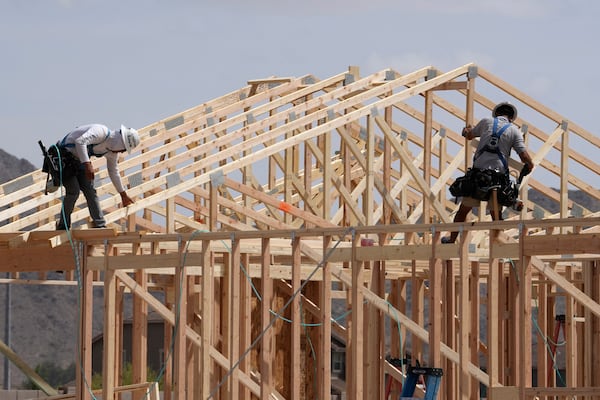 FILE - Construction workers frame up a roof of wood lumber at a new home build, April 1, 2025, in Laveen, Ariz. (AP Photo/Ross D. Franklin, File)