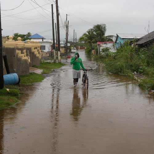 A man wades through a flooded street ahead of the forecasted arrival of Hurricane Melissa in Old Harbour, Jamaica, Monday, Oct. 27, 2025. (AP Photo/Matias Delacroix)
