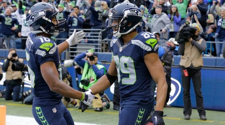 Seattle Seahawks' Tyler Lockett, left, congratulated Doug Baldwin on Baldwin's touchdown pass reception against the Cleveland Browns in the first half of an NFL football game, Sunday, Dec. 20, 2015, in Seattle. (AP Photo/Ted S. Warren)