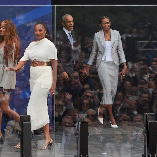 Former President Barack Obama, back center, and former first lady Michelle Obama, right, arrive on stage with their daughters, Sasha and Malia Obama, during the dedication ceremony for the Obama Presidential Center, Thursday, June 18, 2026, in Chicago. (AP Photo/Jeff Roberson)