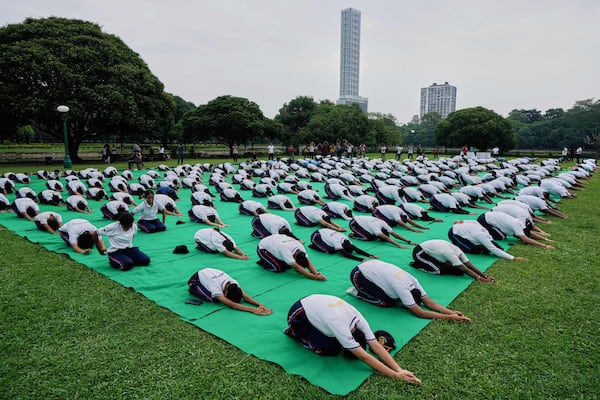 School boys and girls perform yoga on International Yoga Day at Victoria Memorial compound, in Kolkata, India, Saturday, June 21, 2025. (AP Photo/Bikas Das)