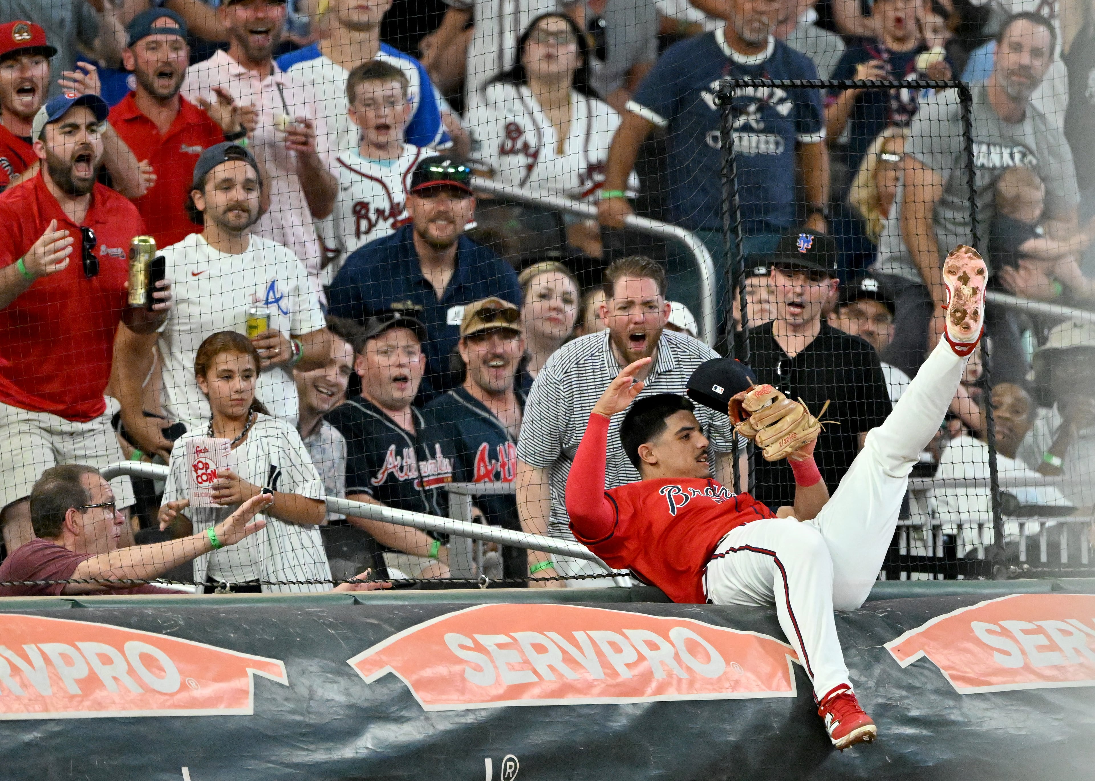 Braves shortstop Nacho Alvarez Jr. collides with the tarp as he catches a fly ball by the Yankees' Austin Wells on Friday, July 18, 2025, in Atlanta. (Hyosub Shin /AJC)