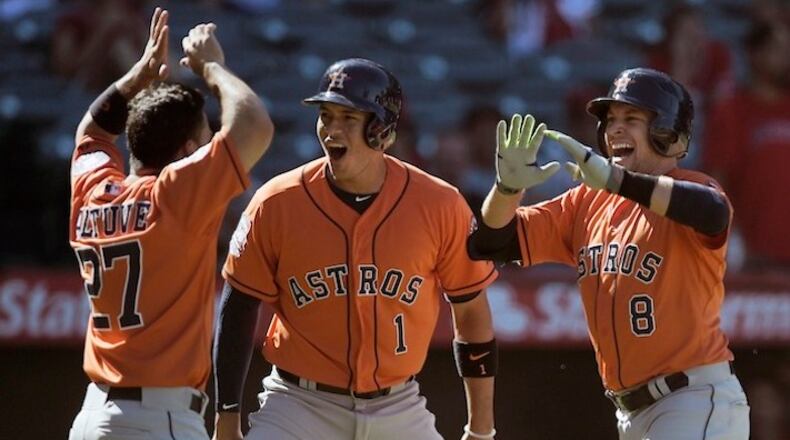 Houston Astros' Jed Lowrie, right, celebrates with Carlos Correa, center, and Jose Altuve, left, after hitting the go-ahead three-run home run off Los Angeles Angels relief pitcher Huston Street during the ninth inning of a baseball game in Anaheim, Calif., Sunday, Sept. 13, 2015. (AP Photo/Kelvin Kuo)