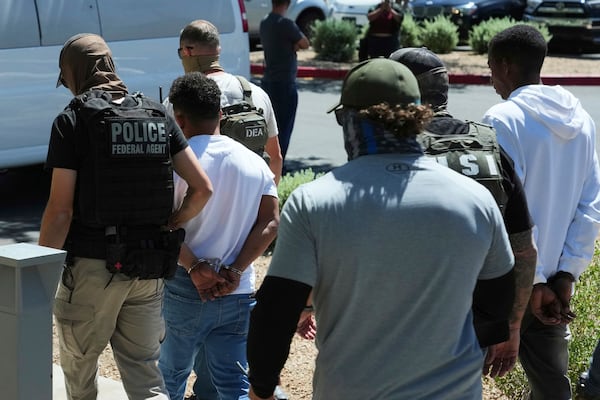 A variety of federal police remove two persons after an immigration court hearing outside an immigration court, Wednesday, May 21, 2025, in Phoenix. (AP Photo/Ross D. Franklin)