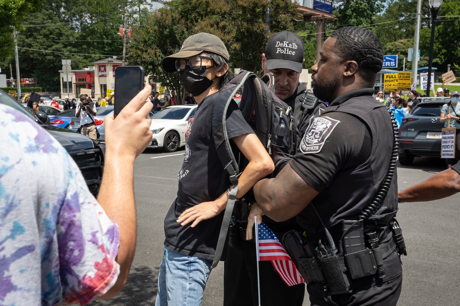 A demonstrator is arrested for refusing to take off their mask during a protest on ICE raids and deportation arrests on Chamblee-Tucker Road in Atlanta on Saturday, June 14, 2025. (Arvin Temkar / AJC)