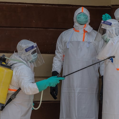 Health workers disinfect themselves after preparing the body of an Ebola victim at Citadelle Clinic in Bunia, Congo, Friday, June 12, 2026. (AP Photo/Moses Sawasawa)