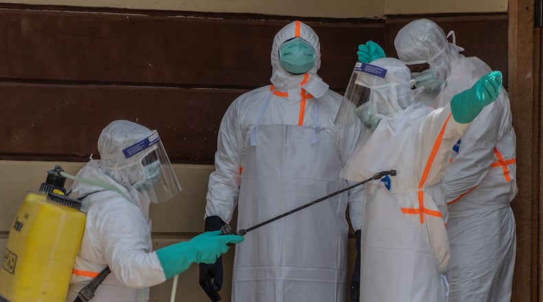 Health workers disinfect themselves after preparing the body of an Ebola victim at Citadelle Clinic in Bunia, Congo, Friday, June 12, 2026. (AP Photo/Moses Sawasawa)