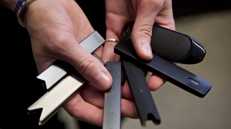 In this April 16, 2019, file photo, a researcher holds vape pens in a lab at Portland State University in in Portland, Ore. (AP Photo/Craig Mitchelldyer, File)