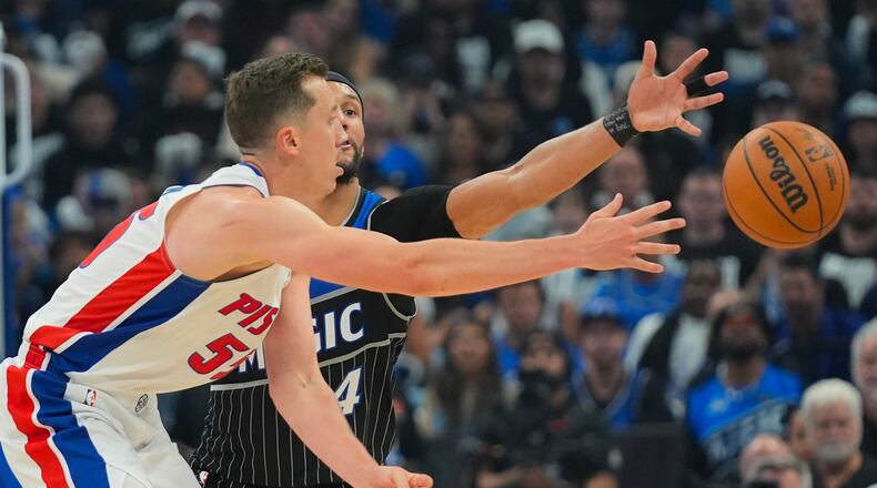 Detroit Pistons forward Duncan Robinson, left, passes the ball against Orlando Magic guard Jalen Suggs (4) during the second half in Game 6 of a first-round NBA basketball playoffs series, Friday, May 1, 2026, in Orlando, Fla. (AP Photo/John Raoux)