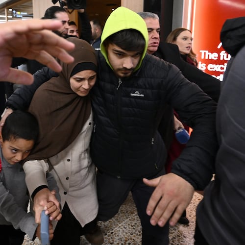 FILE - A group of supporters surround a woman and child with alleged ties to the Islamic State as they arrive at Melbourne international Airport, in Melbourne, Australia, Thursday, May 7, 2026. (Joel Carrett/AAP Image via AP, File)