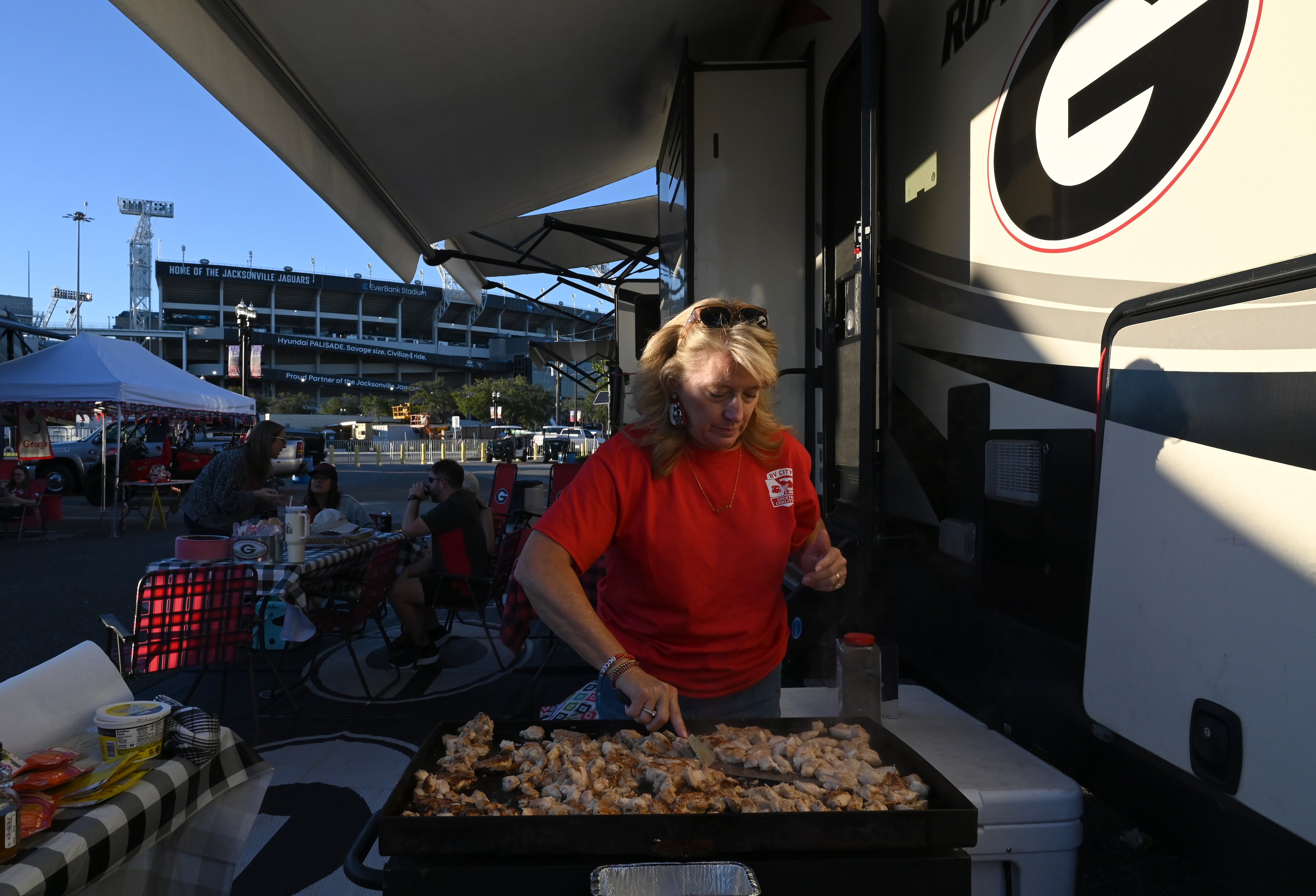 Georgia fan Lisa Freeman cooks chicken during tailgating ahead of the NCAA football game Saturday between Georgia and Florida in RV City outside EverBank Stadium, Friday, October 31, 2025, Jacksonville, Fla. (Hyosub Shin / AJC)
