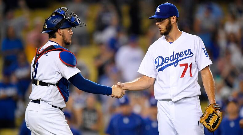Los Angeles Dodgers catcher Yasmani Grandal, left, and relief pitcher Josh Ravin congratulate each other after the Dodgers defeated the Philadelphia Phillies 9-4 in a baseball game, Monday, Aug. 8, 2016, in Los Angeles. (AP Photo/Mark J. Terrill)