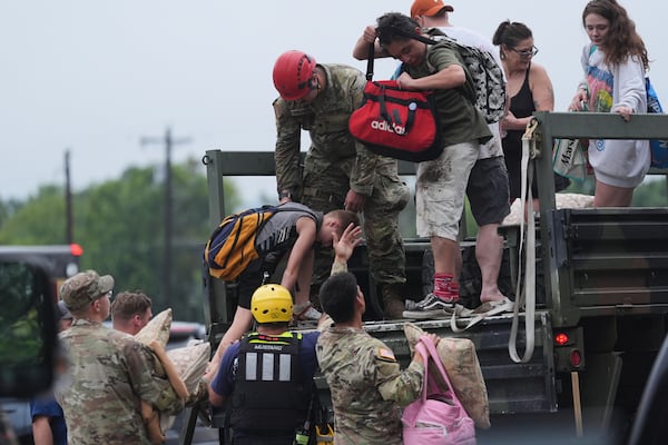 First responders deliver people to a reunification center after flash flooding in the area, Friday, July 4, 2025, in Ingram, Texas. (AP Photo/Eric Gay)