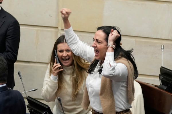 Opposition Senators Paloma Valencia, left, and Maria Fernanda Cabal celebrate after voting against a labor reform referendum proposed by the government, in Bogota, Colombia, Wednesday, May 14, 2025. (AP Photo/Fernando Vergara)
