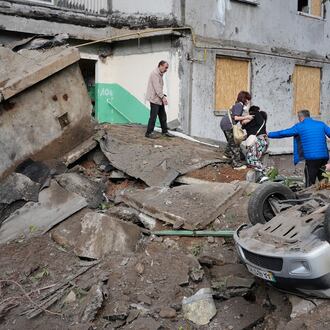 Local residents walk amid debris following a Russian missile attack in Kyiv, Ukraine, Monday, July 6, 2026. (AP Photo/Efrem Lukatsky)