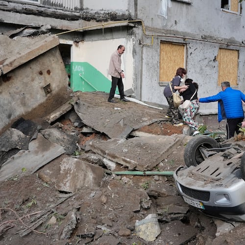Local residents walk amid debris following a Russian missile attack in Kyiv, Ukraine, Monday, July 6, 2026. (AP Photo/Efrem Lukatsky)