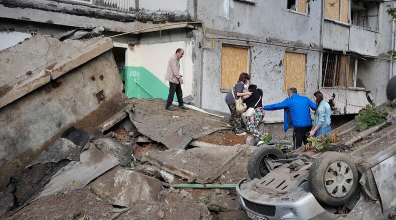 Local residents walk amid debris following a Russian missile attack in Kyiv, Ukraine, Monday, July 6, 2026. (AP Photo/Efrem Lukatsky)
