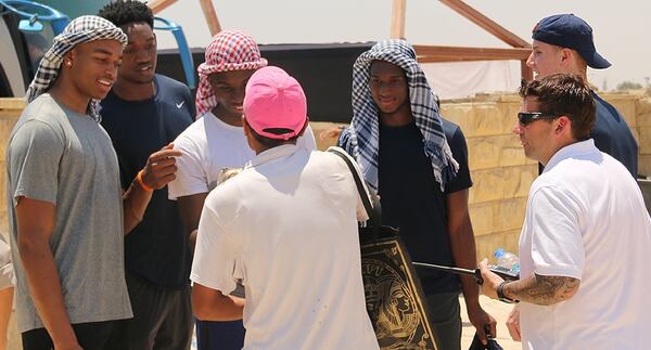 Okogie (navy shirt, blue and white headdress) tried his hand at bartering during his team's visit to the Pyramids of Giza outside Cairo.