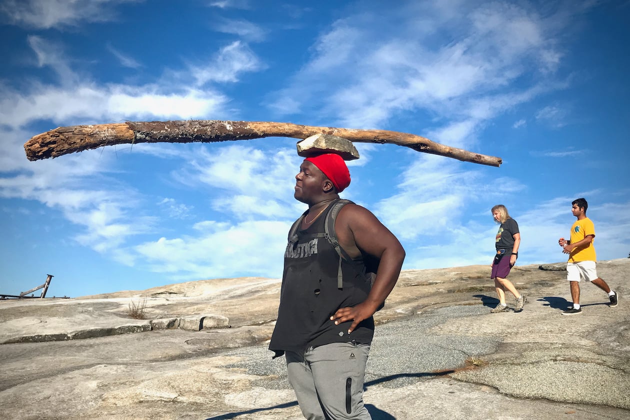 Kofi often hikes Stone Mountain barefoot, carrying a giant stick balanced on a rock on top of his head. (Courtesy of Jean Shifrin)