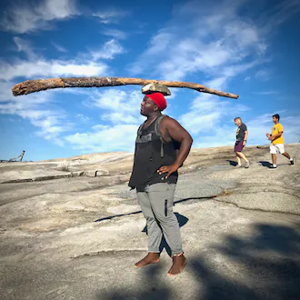 Kofi often hikes Stone Mountain barefoot, carrying a giant stick balanced on a rock on top of his head. (Courtesy of Jean Shifrin)
