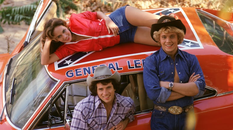 Catherine Bach (Daisy), Tom Wopat (Luke) and John Schneider (Bo) spent a lot of time with the General Lee, which had the Stars and Bars on the roof. CREDIT: CBS