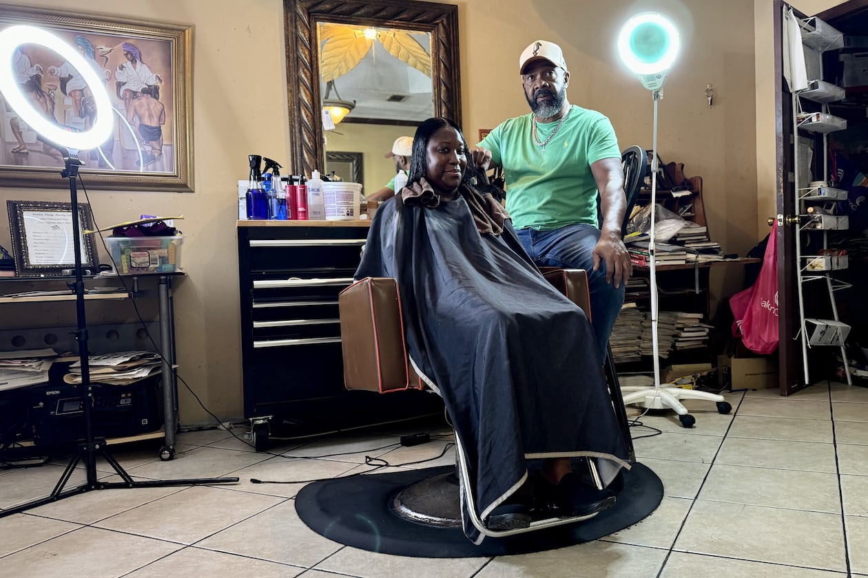 Hair stylist Garrett Milton, 66, tends to a client at his parlor in Fort Valley, the Hidden Image. Milton believes Kamala Harris will win November's presidential election. "You’re getting a Black female running for a Democratic presidency. … I think Black women are going to stand up and fight” for her, he said. (Joe Kovac Jr. / AJC)