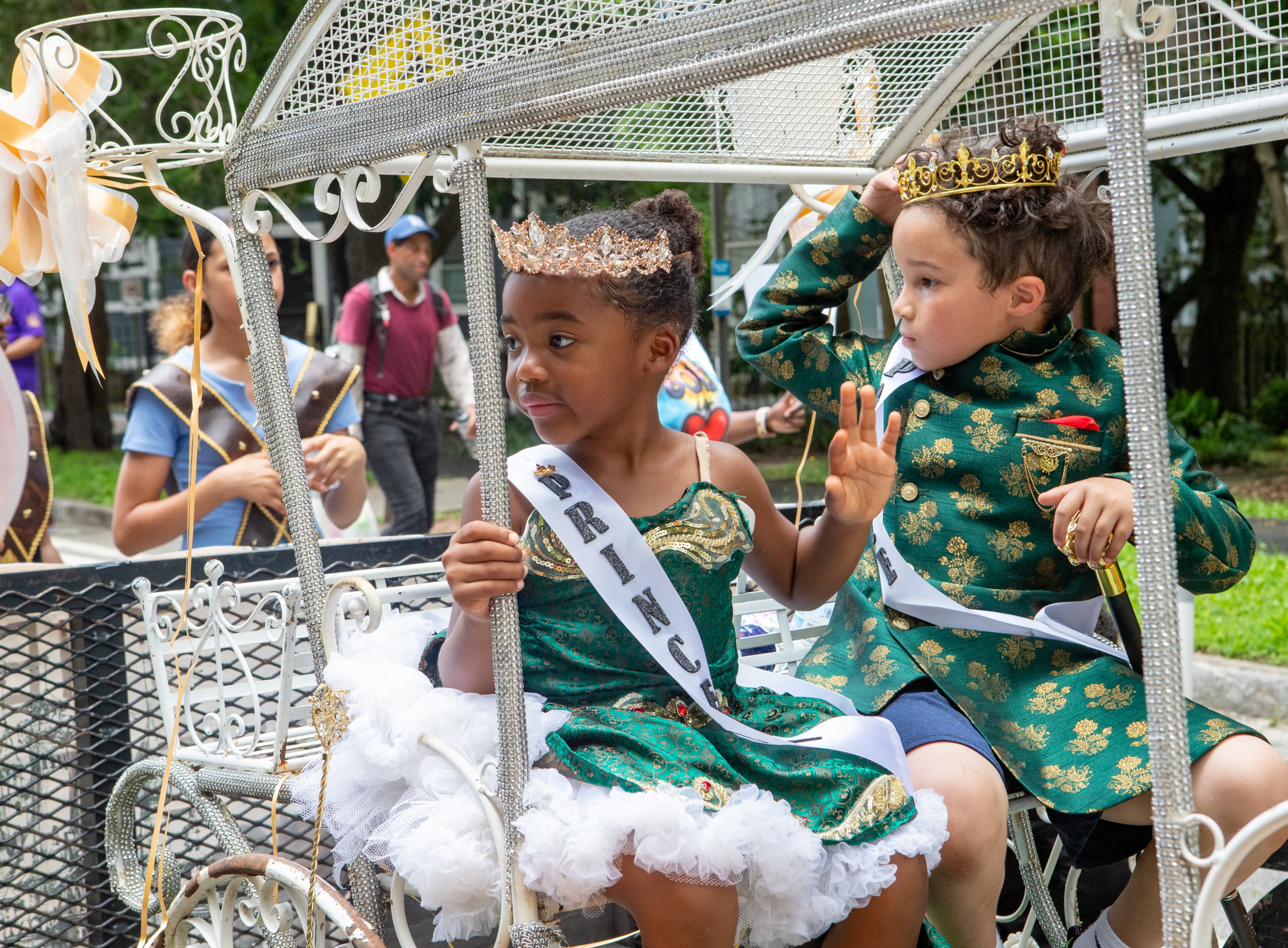 Amelia Hines, left, and London Burden promote a children’s book “The Adventures of Heirs of Royalty” against bullying in the Juneteenth Parade on Monroe Drive in Atlanta on Saturday, June 14, 2025 on their way to Piedmont Park. (Jenni Girtman for The Atlanta Journal-Constitution)