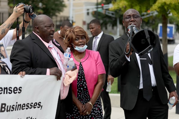 081122 Atlanta, Ga.: Attorney Ben Crump, right, speaks next to Marvin and Mary Grier during a gathering to demand action for the late Brianna Grier at Liberty Plaza across the street from the State Capitol, Thursday, August 11, 2022, in Atlanta. Grier is the woman who died after Hancock Police officers left the door open on the back of the police car after arresting her. Brianna was Marvin and Mary’s daughter. (Jason Getz / Jason.Getz@ajc.com)