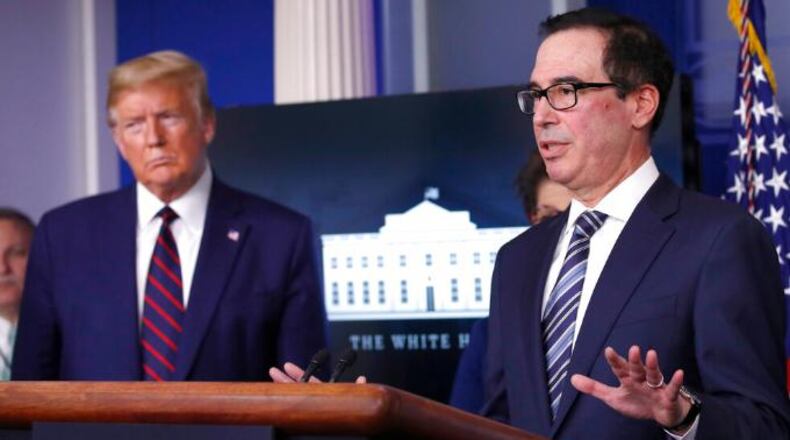 President Donald Trump listens as Treasury Secretary Steven Mnuchin speaks about stimulus checks Thursday in Washington.