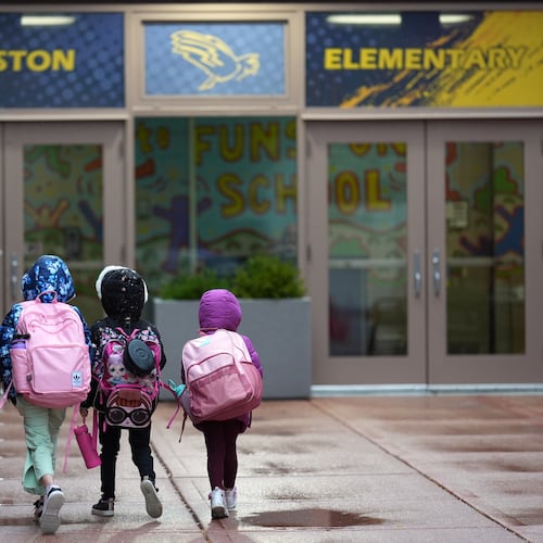 Three sisters, whose single mother fears being mistakenly detained by federal immigration agents because she is of Puerto Rican descent and speaks Spanish, walk into Funston Elementary School after being dropped off for the start of the school day, in Chicago's Logan Square neighborhood, Wednesday, Oct. 15, 2025. (AP Photo/Rebecca Blackwell)