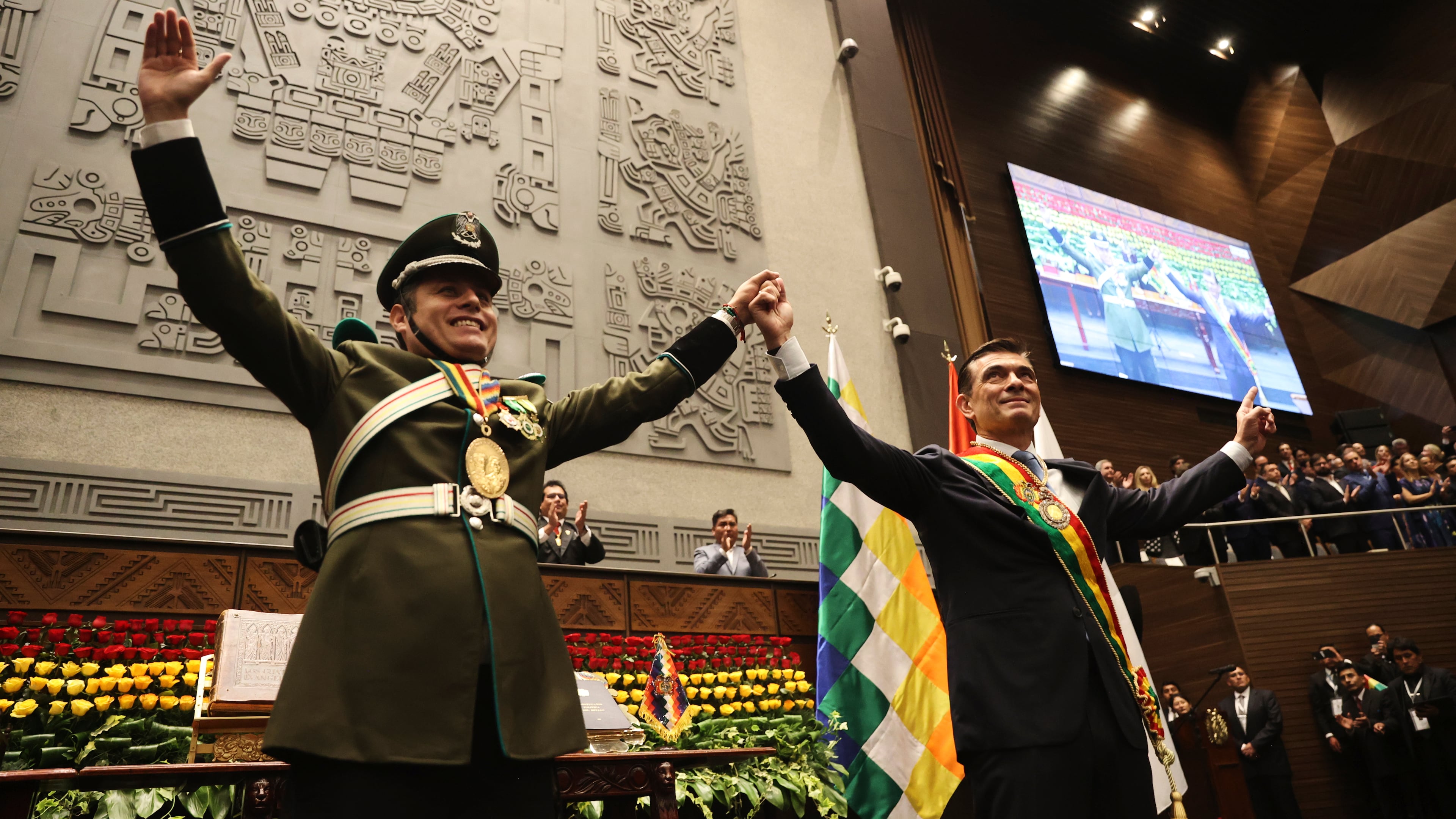 President Rodrigo Paz, right, and Vice President Edman Lara hold hands after the swearing-in ceremony in La Paz, Bolivia, Saturday, Nov. 8, 2025. (Luis Gandarillas, Pool Photo via AP)