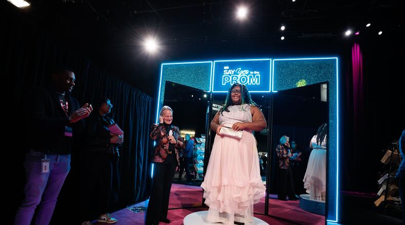 After getting advice from Monte Durham (left), host of the event “Say Yes to the Prom,“ McNair High School junior Bricelyn Armstead said "yes" to a pink gown at Warner Brothers Discovery's campus in Midtown on Tuesday, Feb. 6, 2024. (Miguel Martinez /miguel.martinezjimenez@ajc.com)