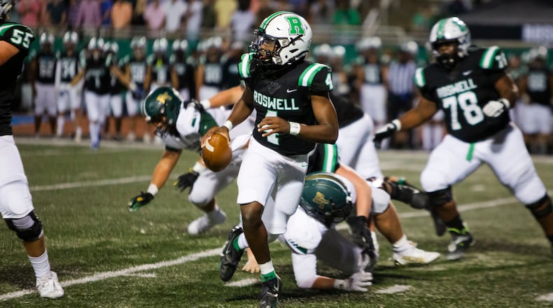 Roswell quarterback KJ Smith scrambles away from pressure during Thursday's game against Blessed Trinity. (Christina Matacotta/For the AJC)